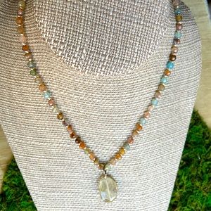 Faceted agate necklace with rutillated quartz pendant.